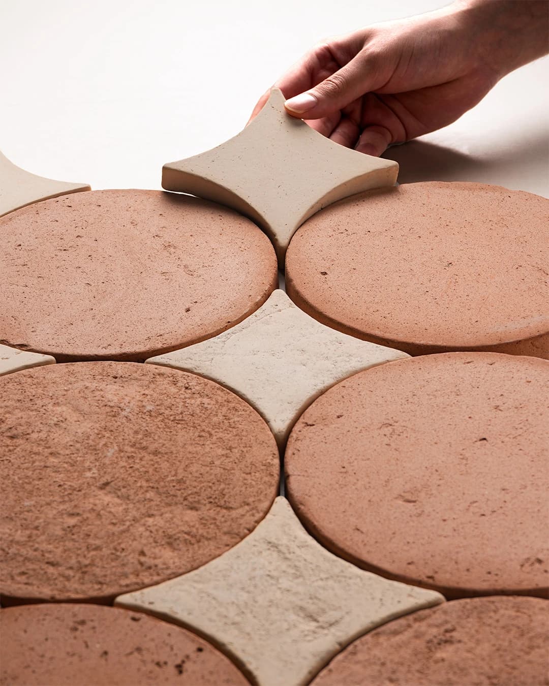 Composition of circular-format tiles in TERRA® terracotta.
