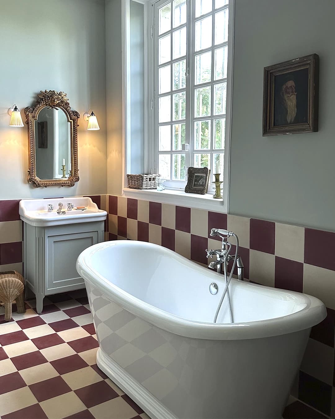White and red checkerboard cement tiles on the floor and walls of a bathroom.