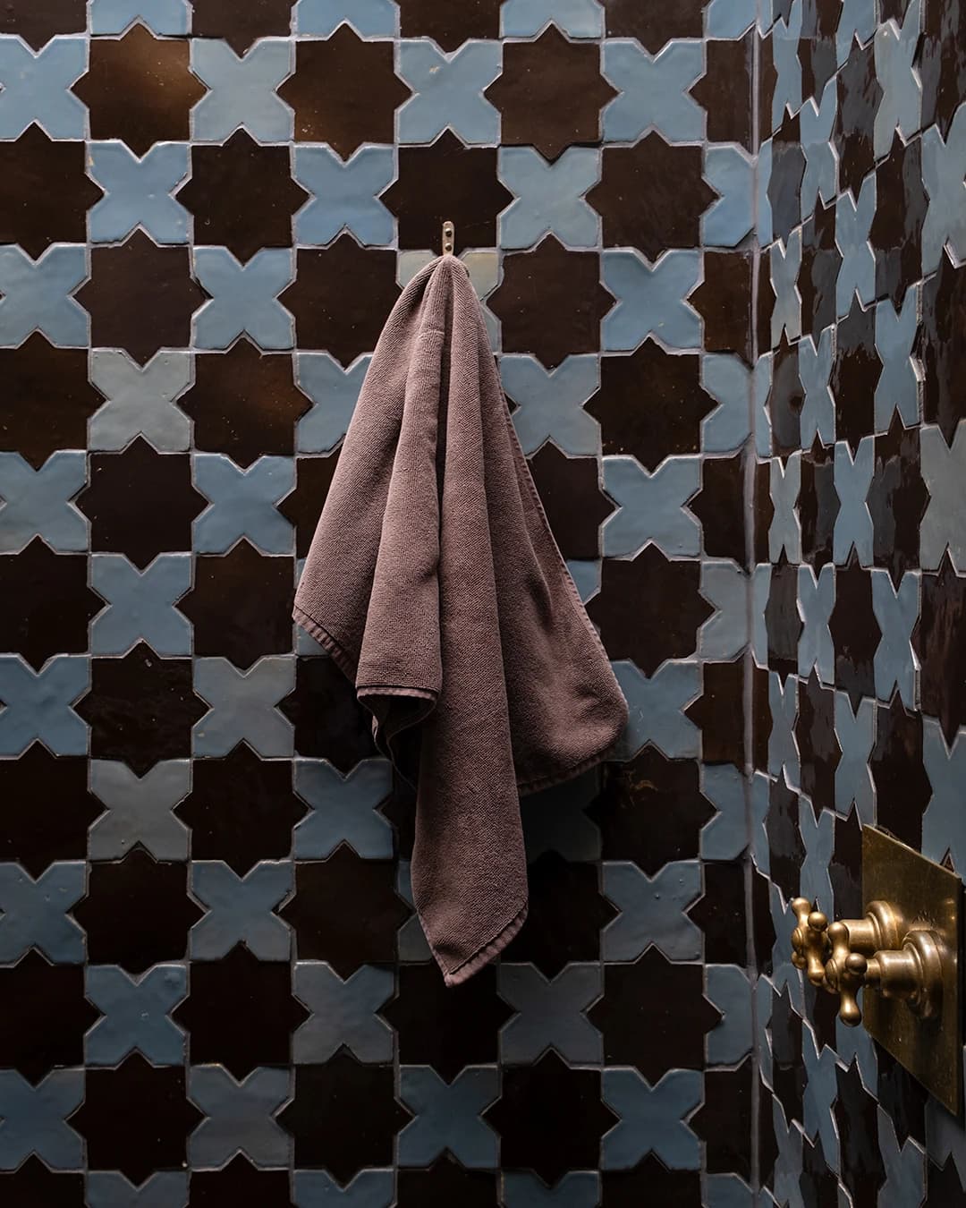 Shower walls in oriental-patterned Zellige with a matching border.
